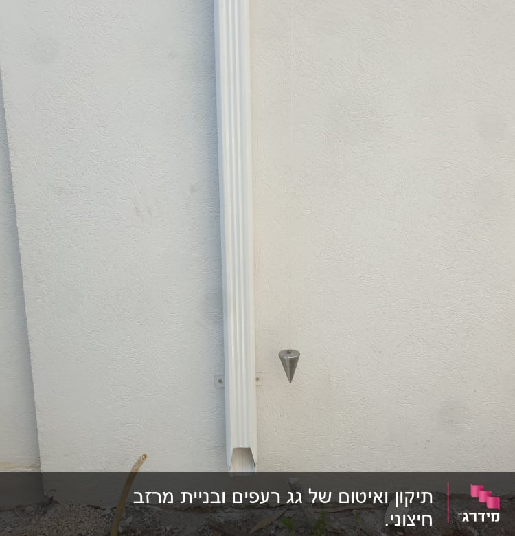צינור מרזב לבן מחובר לקיר חיצוני